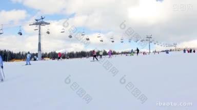 许多滑雪者在他们身后移动的长吊车的业余山路上滑雪